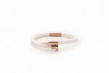 White bracelet with rose gold accents on a white background