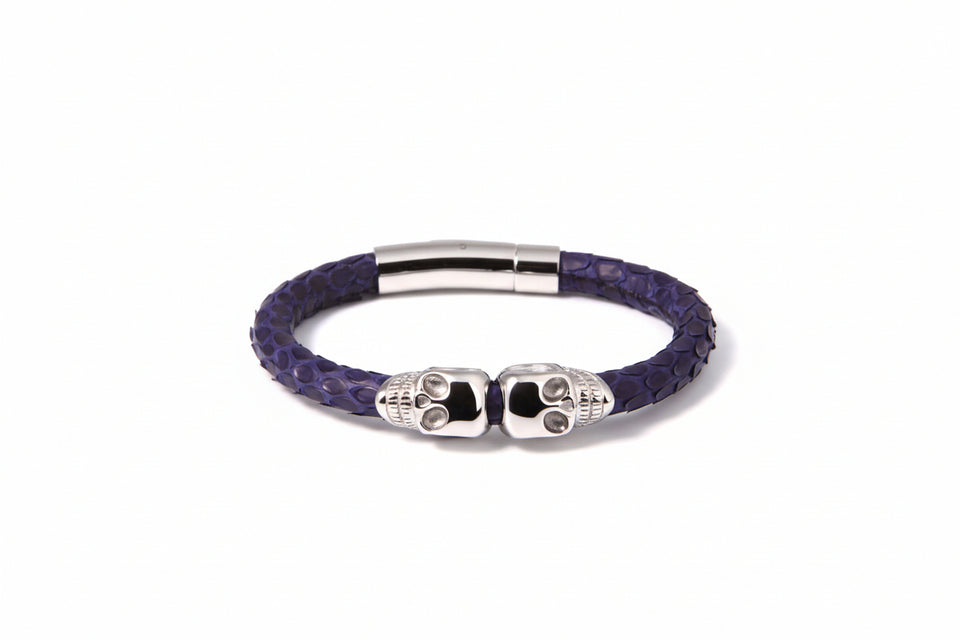 Purple braided bracelet with silver skull charm on a white background