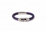 Purple braided bracelet with silver skull charm on a white background