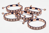 Set of rose gold and black bracelets on a white background