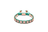A bronze and turquoise cubic zirconia diamond bracelet with 18k rose gold plating.