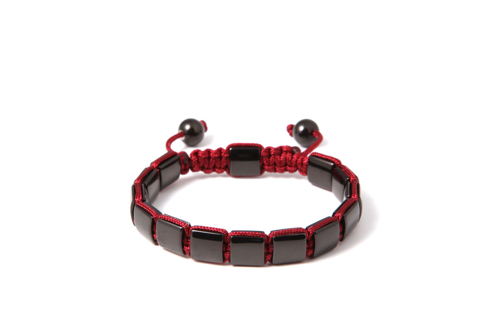 A black stainless steel square bracelet with red cord.